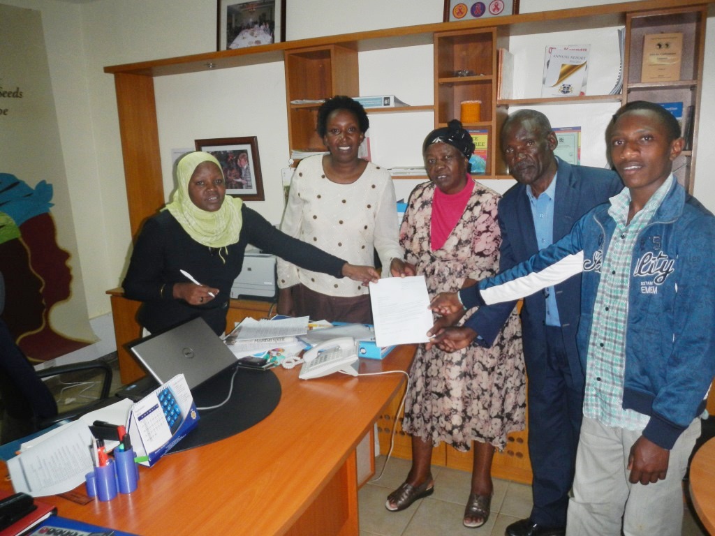 James Ndiritu Nyaguthi, 19, beneficiary of the GBM scholarship scheme handing over a thank you note.