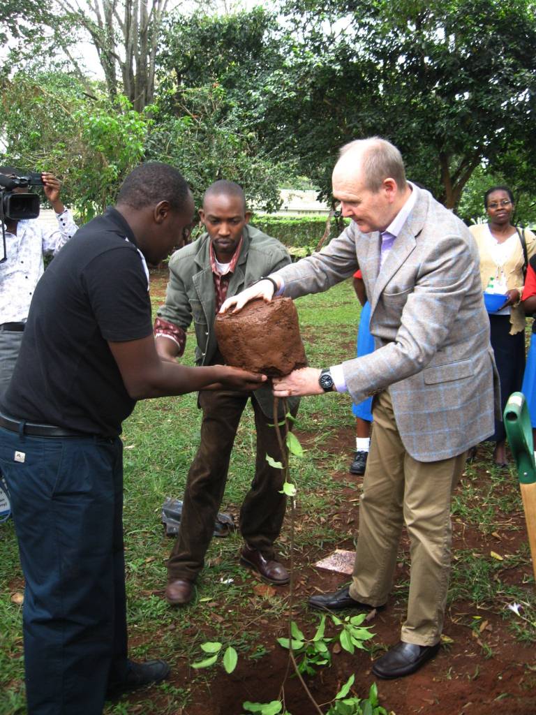 Sir John Peace being assisted by GBM Project Officer Edwin Ngungiri and Senior Programme Officer Charles Peter Mwangi in planting the tree