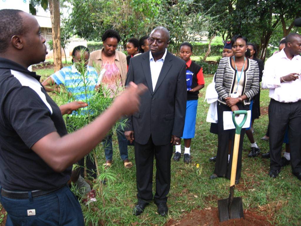 Senior Programme Officer, Charle Peter Mwangi explaining to the Mr. Iamin Manjang CEO of the Standard Chartered Bank the steps to be undertaken before planting the tree, the type and its significance