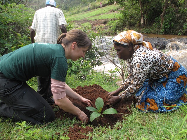A member of the McKinsey group planting trees together with the community members and discussing the social, economic and environmental impact of GBM and GBS with them.